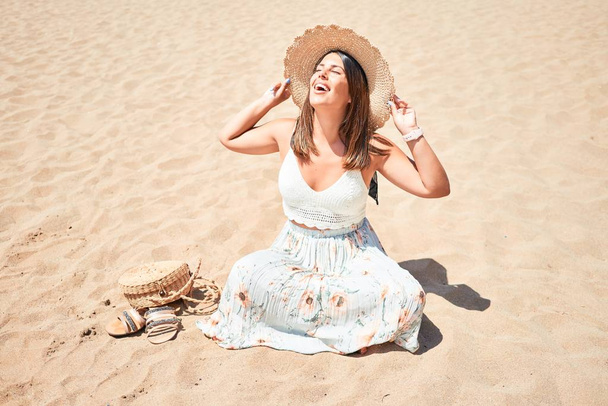 junge schöne Frau lächelt glücklich genießen Sommerurlaub am Strand sitzt auf der Sonne - Foto, Bild