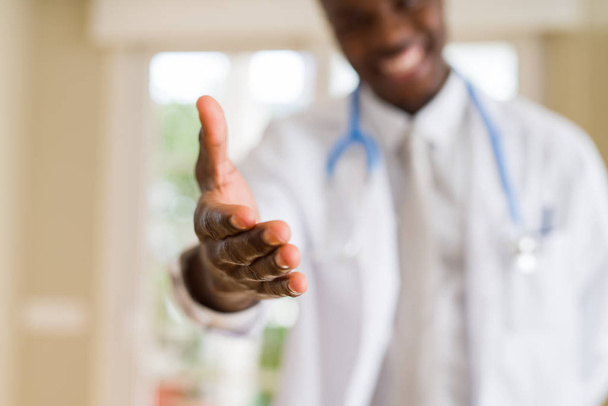 Detailní záběr africké lékaře nabízí ruku pro shake úvodní ruku a usmívá se - Fotografie, Obrázek