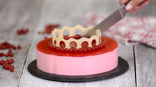 Vrouwen handen snijden een zelfgemaakte rode bessen mousse cake. - Video