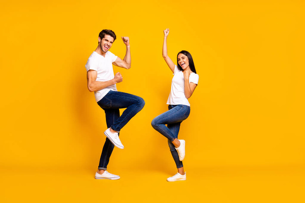Full body photo of pair lady and guy fans supporting favorite football team raising fists wear casual outfit isolated yellow color background - Foto, immagini