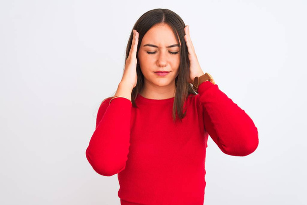 Young beautiful girl wearing red casual t-shirt standing over isolated white background with hand on head for pain in head because stress. Suffering migraine. - Foto, afbeelding
