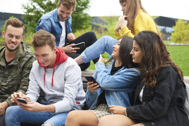 Група молодих людей за допомогою мобільного телефону
  - Фото, зображення