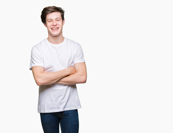 Молодий красивий чоловік у повсякденній білій футболці над ізольованим тлом щасливе обличчя, що посміхається схрещеними руками, дивлячись на камеру. Позитивна особа
. - Фото, зображення