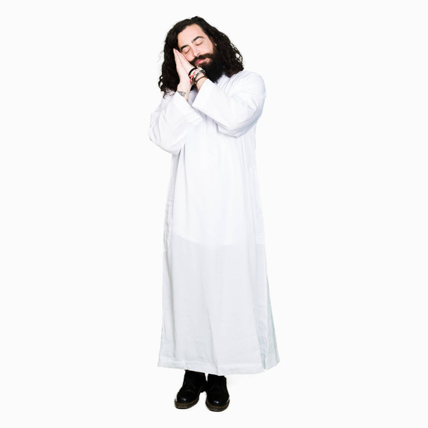 Man wearing Jesus Christ costume sleeping tired dreaming and posing with hands together while smiling with closed eyes. - Photo, Image