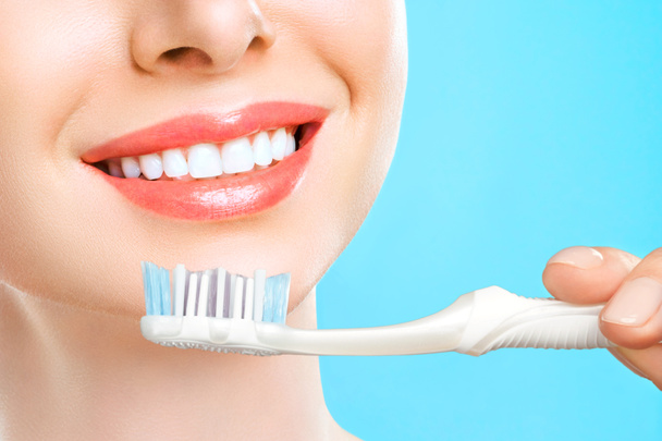Portrét atraktivní kavkazské usmívající se ženy izolované na bílém ateliéru záběr čištění zubů - Fotografie, Obrázek