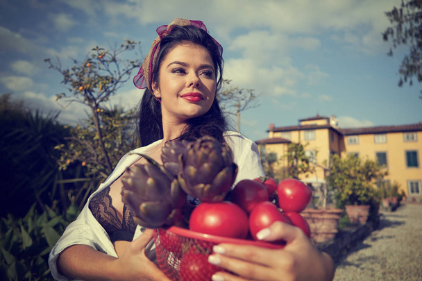 La dolce vita lifestyle. An Italian woman is carrying a basket w - Photo, Image