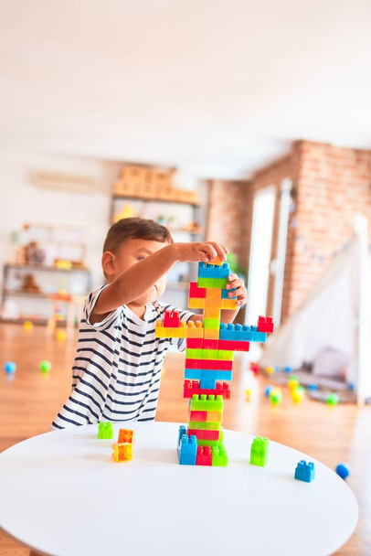 Hermoso niño jugando con bloques de construcción en el jardín de infantes
 - Foto, imagen