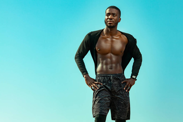 Young sportsmen man, fit athlete are standing on the sky background. Healthy lifestyle, sport fashion. Guy in black sportswear. Fitness concept. - Φωτογραφία, εικόνα