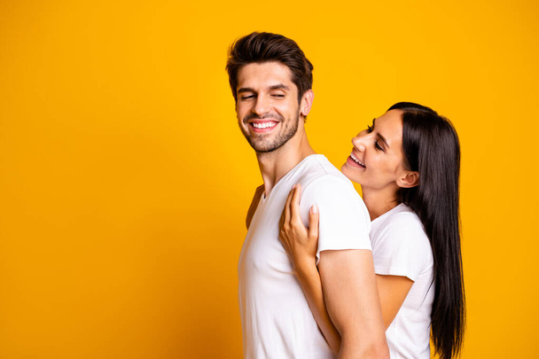 Profile photo of amazing pair in love lady holding piggyback strong back of guy wear casual white t-shirts isolated yellow color background - Photo, Image