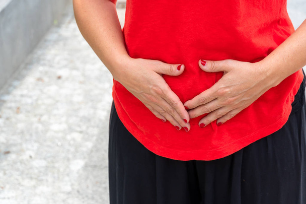 Εγκυμοσύνη ή πόνο στο στομάχι. Γυναίκα με εμμηνορροϊκό ή κοιλιακό πόνο - Φωτογραφία, εικόνα