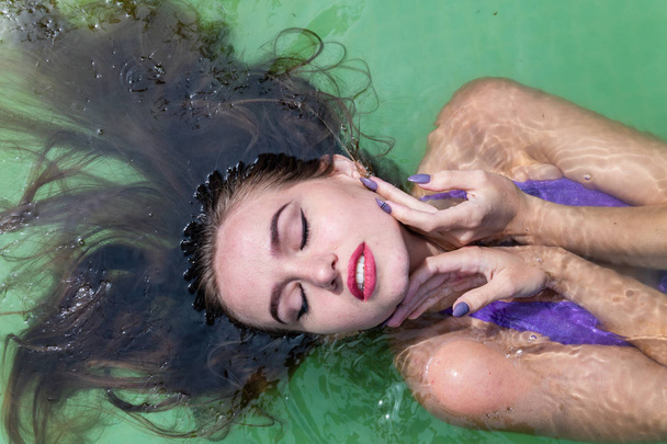 Мокра модель приймає душ і плаває в одязі, мокрій одязі, вологому погляді жіночій, сауні та басейні
 - Фото, зображення