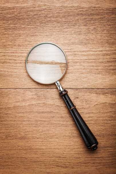 Magnifying glass on wooden background - Valokuva, kuva
