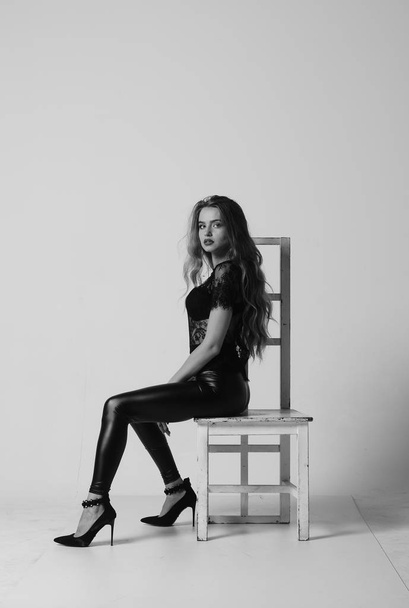 Stunning brunette beauty sitting on a chair - 写真・画像