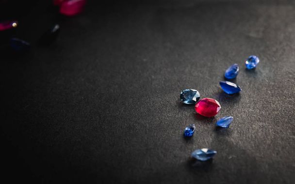 Colección de rubí rojo y zafiro azul, Piedras preciosas para joyas sobre fondo negro
 - Foto, imagen