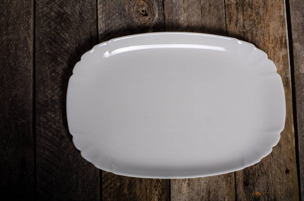 Top view of blank white dish and white stablecloth on a wood background with copy space
 - Фото, изображение