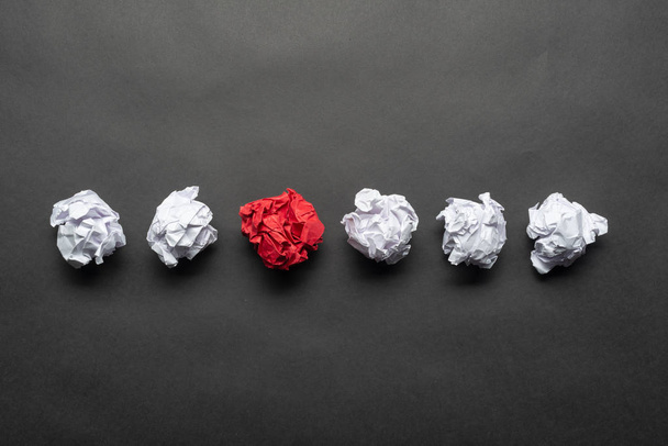 Zmačkané červené papírové koule mezi bílými míčky - Fotografie, Obrázek