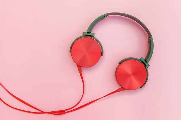 Red headphones with cable isolated on pink pastel colorful background - Photo, Image