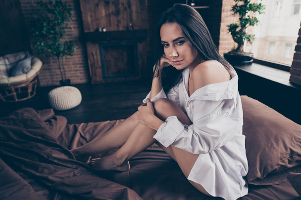 Portrait of her she nice-looking attractive lovely lovable sweet gorgeous charming pretty girl sitting on bed waiting boyfriend partner at industrial brick wood loft modern interior style house - Foto, Imagem