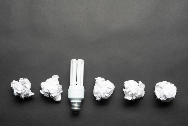 Leuchtstofflampe und zerknüllte weiße Papierkugeln - Foto, Bild