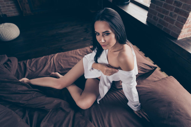 Portrait of her she nice-looking gorgeous attractive lovely lovable pretty girl sitting on bed bare foot teasing you undressing at industrial brick wood loft modern interior style flat hotel indoors - Foto, Bild
