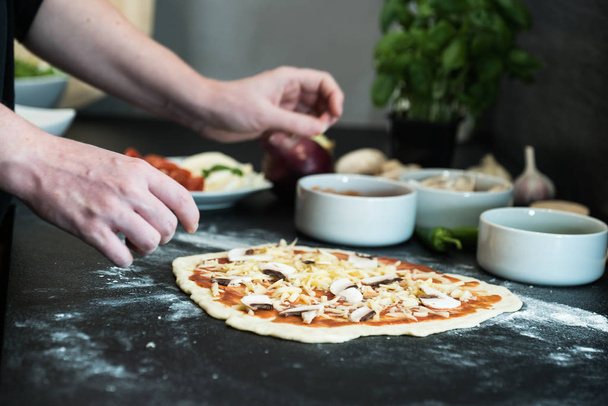 Woman preparing pizza at home - Foto, afbeelding