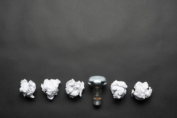 Lâmpada e bolas de papel branco amassadas
 - Foto, Imagem