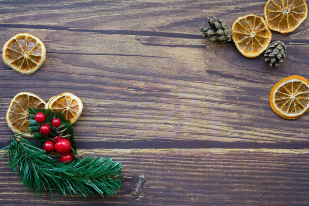 Sfondo natalizio da arance secche, ramoscello di pino e bacche rosse decorative su un tavolo di legno. Felice anno nuovo
. - Foto, immagini