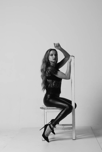 Stunning brunette beauty sitting on a chair - Foto, Imagem