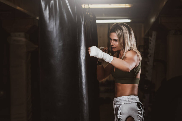 女性ボクサーの肖像画で彼女のトレーニングとともにパンチングバッグ - 写真・画像