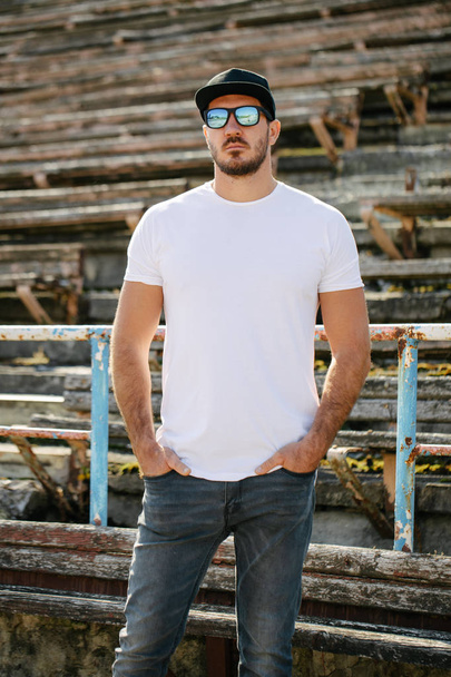 Hipster jóképű férfi modell szakáll visel fehér üres póló és egy baseball sapka helyet a logó vagy design alkalmi városi stílusban - Fotó, kép