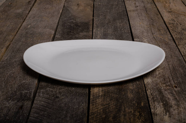 Top view of blank white dish and white stablecloth on a wood background with copy space
 - Фото, изображение