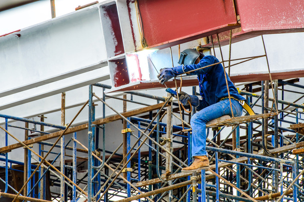 A Construction Worker welding steel bars on scaffold in construction site. - Photo, Image