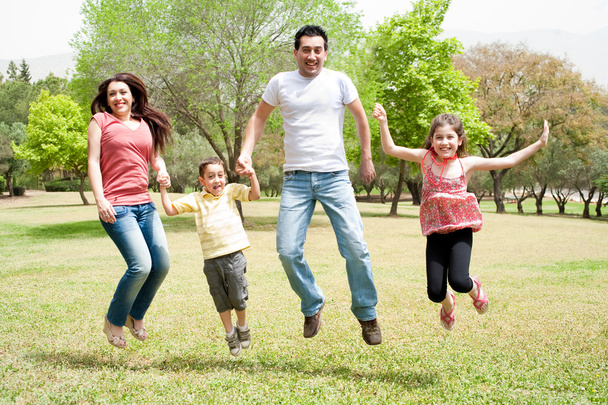 Family jumping together in the park - Photo, image