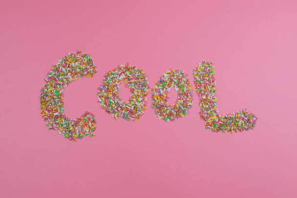 Mot COOL écrit avec des bonbons sur un fond rose
 - Photo, image