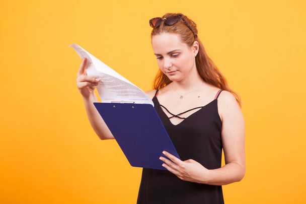 Уверенная молодая девушка читает документ в своем блокноте
 - Фото, изображение