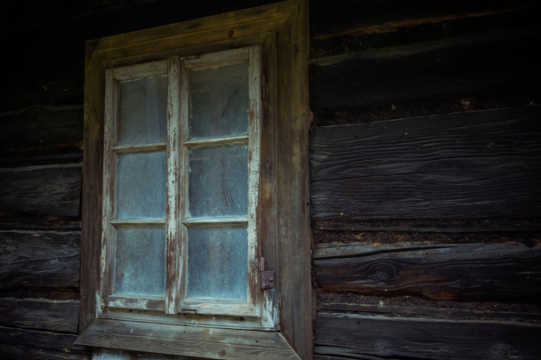 Παλιό τρομακτικό παράθυρο σε ξύλινο σπίτι. Απόκριες, στοιχειωμένο σπίτι έννοια. - Φωτογραφία, εικόνα