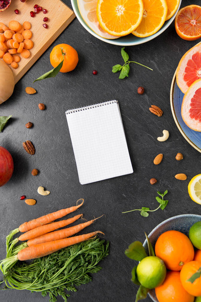 close up of notebook, fruits and vegetables - Foto, immagini