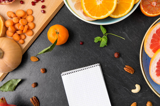 close up of notebook, fruits and vegetables - Fotó, kép