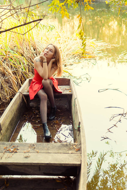A woman is posing in front of a camera in an autumn park. autumn photo shoot. Autumn in the park. - Photo, image
