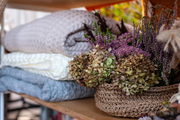 груда теплых красочных одеял рядом с деревенской вязаной корзиной с
 - Фото, изображение
