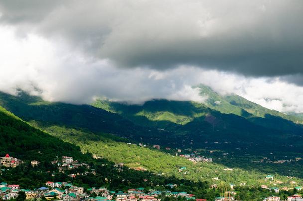 Estación de colina en la India con edificios y colinas cubiertas de hierba con sombras de nubes que caen sobre ellos
 - Foto, Imagen