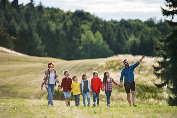 Skupina školních dětí s učitelem na polní cestě v přírodě, chůze. - Fotografie, Obrázek