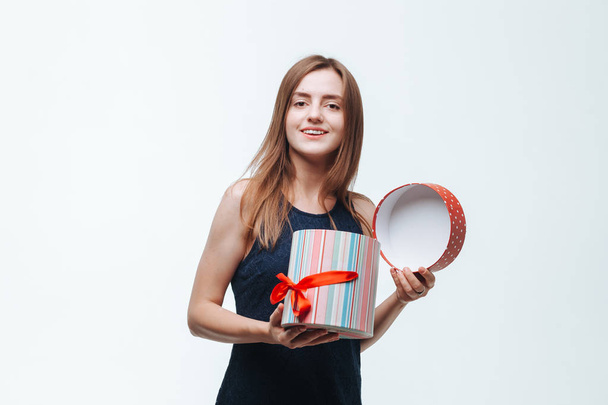 The girl received a gift box and is happy on a light background - Фото, зображення