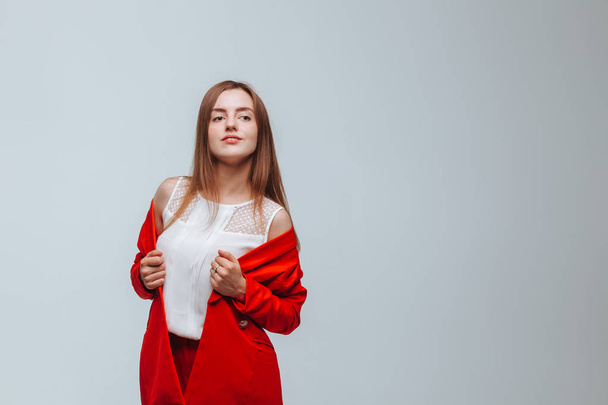 Girl in a red jacket on a light background - Фото, зображення