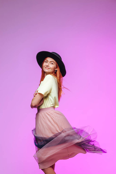 Chica pelirroja en el viento en una falda voladora en un sombrero
 - Foto, Imagen