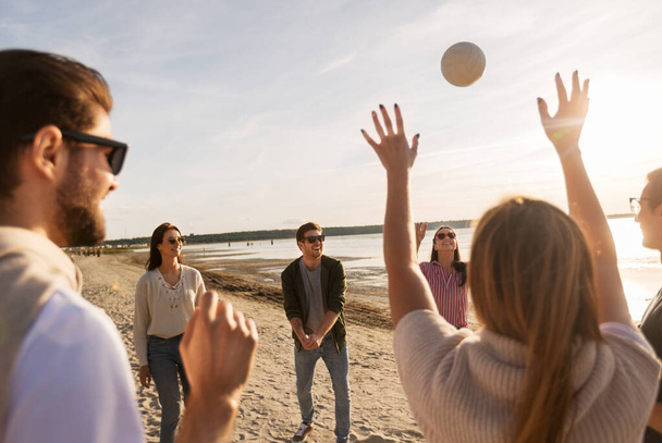 friends playing volleyball on beach in summer - Valokuva, kuva