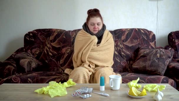 fille malade sous une couverture frissonnant de fièvre pendant la maladie assis sur le canapé à la maison
 - Séquence, vidéo