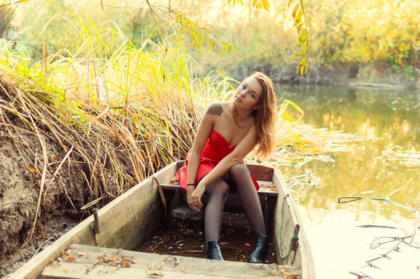 A woman is posing in front of a camera in an autumn park. autumn photo shoot. Autumn in the park. - Foto, afbeelding