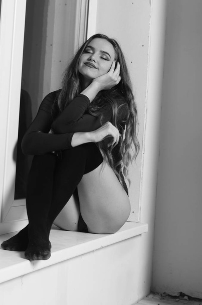 Mujer joven y sexy con gran pecho. Chica posando en negro pared en s
 - Foto, Imagen