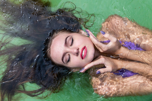 Natte model neemt een douche en zwemt in kleding, natte kleding, natte kijken vrouwen, sauna en zwembad - Foto, afbeelding